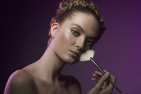 Female putting makeup on with a brush